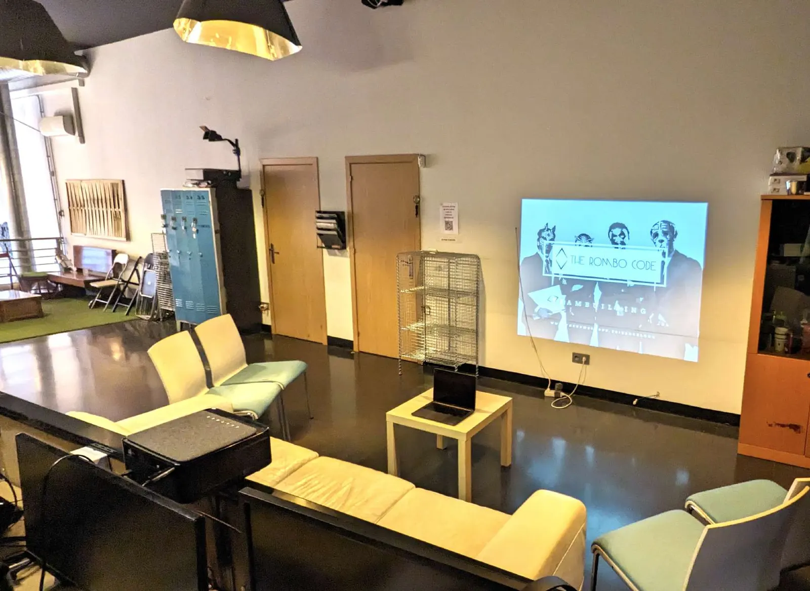 Zona comuna amb projector i sofàs per a reunions