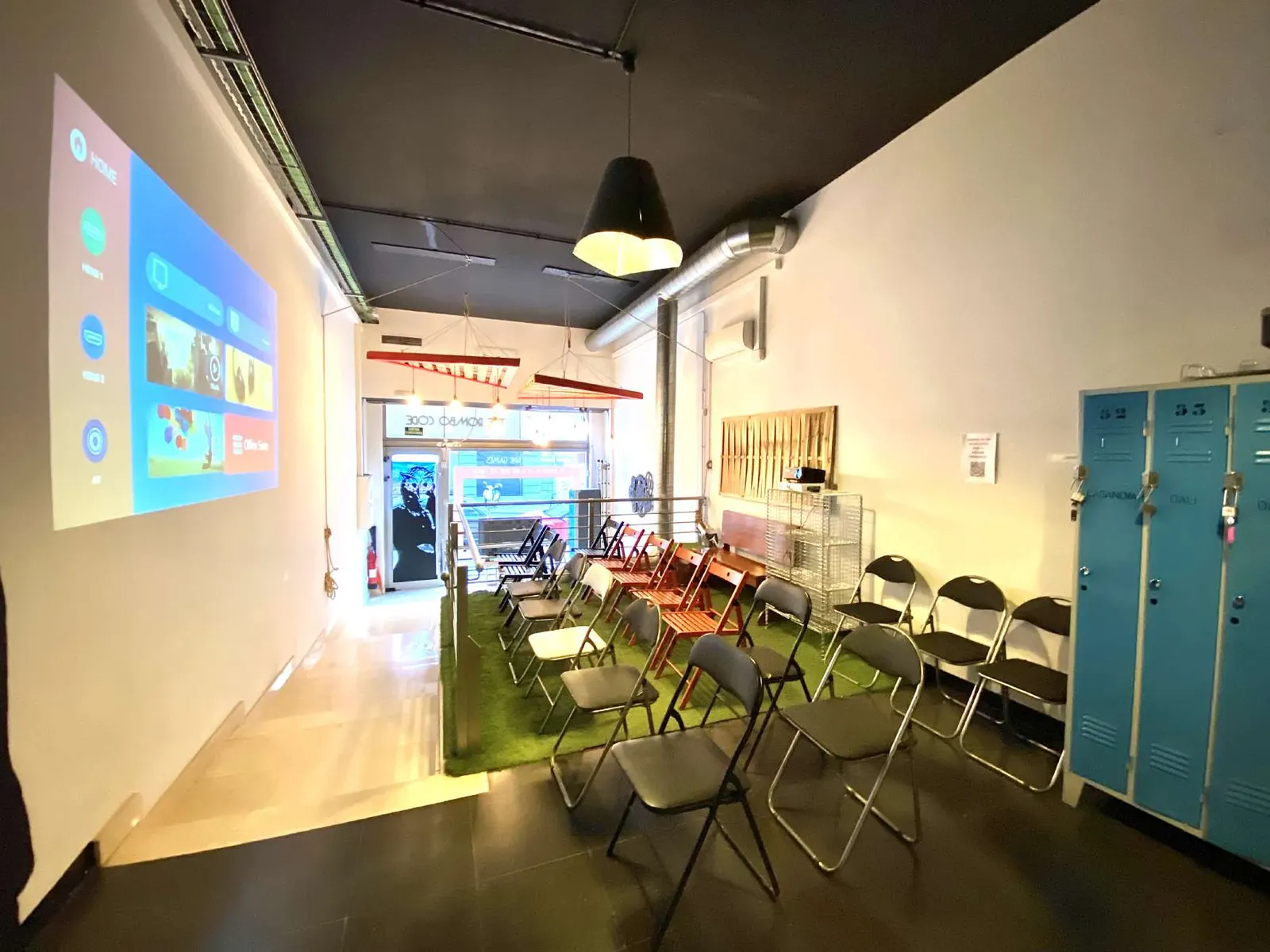 Zona comuna amb cadires muntades davant la pantalla del projector per a una presentació